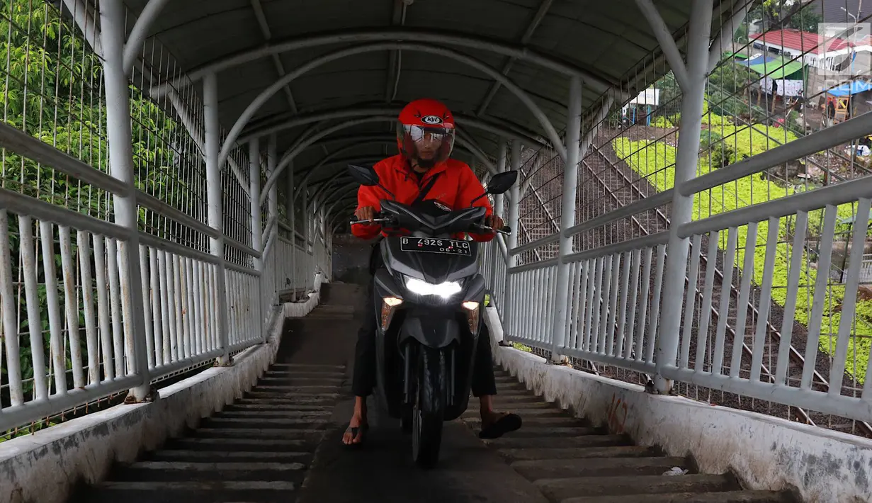 Pemotor melintasi jembatan penyeberangan orang (JPO) di kawasan Pasar Minggu, Jakarta, Rabu (24/4). Kurangnya kesadaran akan tertib berlalu lintas menyebabkan para pemotor itu nekat melintasi JPO, meskipun dapat merugikan hak pejalan kaki. (Liputan6.com/Immanuel Antonius)