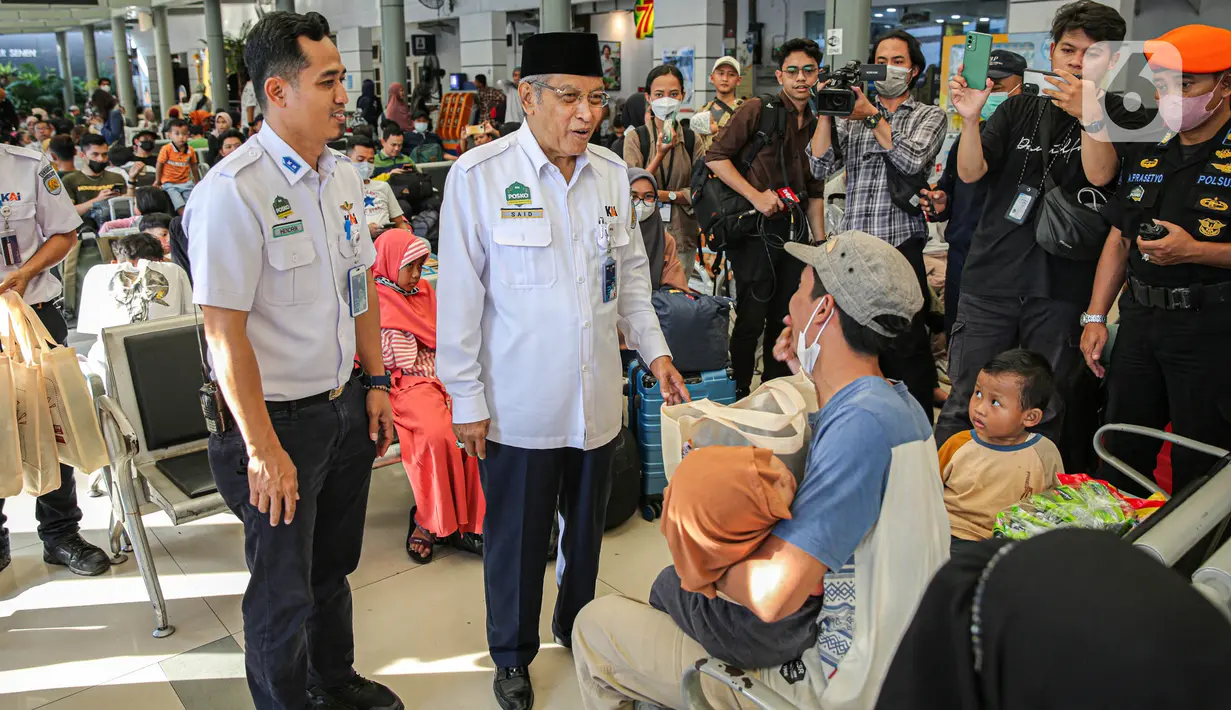 Komisaris Utama PT KAI Said Aqil Siraj (tengah) membagikan bingkisan kepada penumpang saat melakukan pengecekan di Stasiun Pasar Senen. (Liputan6.com/Faizal Fanani)