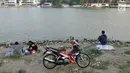 Warga memarkir sepeda motornya secara sembarangan saat memancing di Danau Sunter, Jakarta, Senin (22/7/2019). Tidak adanya fasilitas parkir di kawasan tersebut menyebabkan pengunjung Danau Sunter memarkirkan sepeda motor mereka secara sembarangan. (merdeka.com/Iqbal Nugroho)