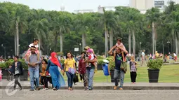 Rombongan warga berjalan-jalan di kawasan Monumen Nasional, Jakarta, Minggu (25/12). Libur perayaan Natal 2016 dimanfaatkan sejumlah warga untuk berwisata di kawasan Monumen Nasional. (Liputan6.com/Helmi Fithriansyah)