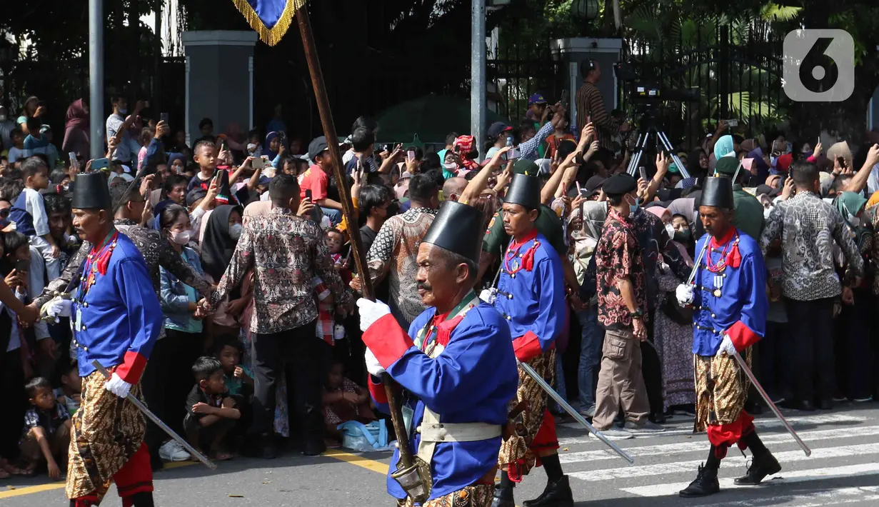 Jajaran Abdi Dalem Keraton Surakarta mengawal prosesi kirab Ngunduh Mantu Kaesang Pangarep dan Erina Gudono di kawasan Selamet Riyadi, Solo, Jawa Tengah, Minggu (11/12/2022). Dalam kirab tersebut, Kaesang-Erina disambut oleh ribuan warga yang menunggu di pinggir jalan. (Liputan6.com/Herman Zakharia)