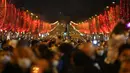 Orang-orang merayakan malam Tahun Baru di Jalan Champs Elysees, Paris, Prancis, Jumat (31/12/2021). (AP Photo/Thibault Camus)