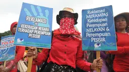Seorang massa memegang poster saat aksi long march menuju Istana Presiden, Jakarta, Selasa (8/3). Aksi memperingati Hari Perempuan Internasional ini menuntut pemerintah memberikan perlindungan terhadap perempuan Indonesia. (Liputan6.com/Gempur M Surya)
