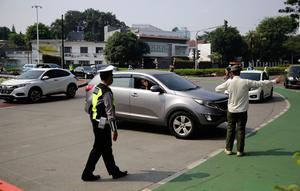 Petugas polisi mengarahkan kendaraan berplat nomor genap di pos penyekatan ganjil-genap di Bundaran Senayan, Minggu (5/9/2021). Pembatasan kendaraan dengan sistem pelat nomor kendaraan ini tetap berlaku di akhir pekan, Sabtu dan Minggu. (Liputan6.com/Angga Yuniar)
