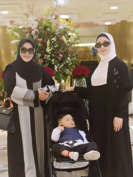 Nikita Willy mengenakan outer panjang dan inner gamis hitam. Dipadukan kerudung putih model lilit. [@yorafebrina]