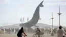 Peserta berkumpul di sekitar seni instalasi The Space Whale dalam Festival Burning Man, di padang pasir Black Rock, Nevada, Amerika Serikat. (01/09). Festival ini mengusung semangat kreativitas tanpa batas. (REUTERS/Jim Urquhart)