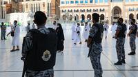 Pasukan keamanan Arab Saudi berjaga saat jemaah haji pertama pada awal musim haji tiba di Masjidil Haram, Arab Saudi, Sabtu (17/7/2021). Jumlah jemaah yang akan melaksanakan ibadah haji tahun ini sebanyak 60 ribu. (FAYEZ NURELDINE/AFP)