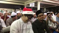 Pria bernama Alim memakai topi Santa Klaus berwarna merah putih lengkap dengan tulisan Merry Christmas saat Haul ke-7 Gus Dur. (Liputan6.com/Taufiqqurohman)