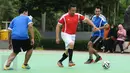 Menpora Imam Nahrawi (tengah) melewati dua pewarta olahraga saat bermain futsal di Lapangan Kemenpora, Jakarta, Jumat (10/2). Laga futsal ini untuk memeriahkan Hari Pers Nasional 2017 di lingkungan Kemenpora. (Liputan6.com/Helmi Fithriansyah)