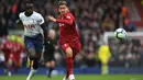 Roberto Firminho lewati Davindon Sanchez pada laga lanjutan Premier League yang berlangsung di Stadion Anfield, Liverpool, Minggu (31/3). Liverpool menang 2-1 atas Tottehnam Hotspur. (AFP/Paul Ellis)