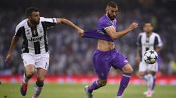 Striker Real Madrid, Karim Benzema, berusaha melewati bek Juventus, Andrea Barzagli, pada laga final Liga Champions di Stadion Stadion Millenium, Cardiff, Sabtu (3/6/2017). Madrid menang 4-1 atas Juventus. (AFP/Filippo Monteforte)