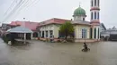 Setidaknya 13 orang dilaporkan tewas akibat banjir di beberapa provinsi di Thailand selatan, termasuk Songkhla. Tampak dalam foto, seorang anak bersepeda di tengah banjir di dekat sebuah masjid di provinsi Narathiwat, Thailand selatan, pada Selasa 25 November 2025. (Madaree TOHLALA/AFP)