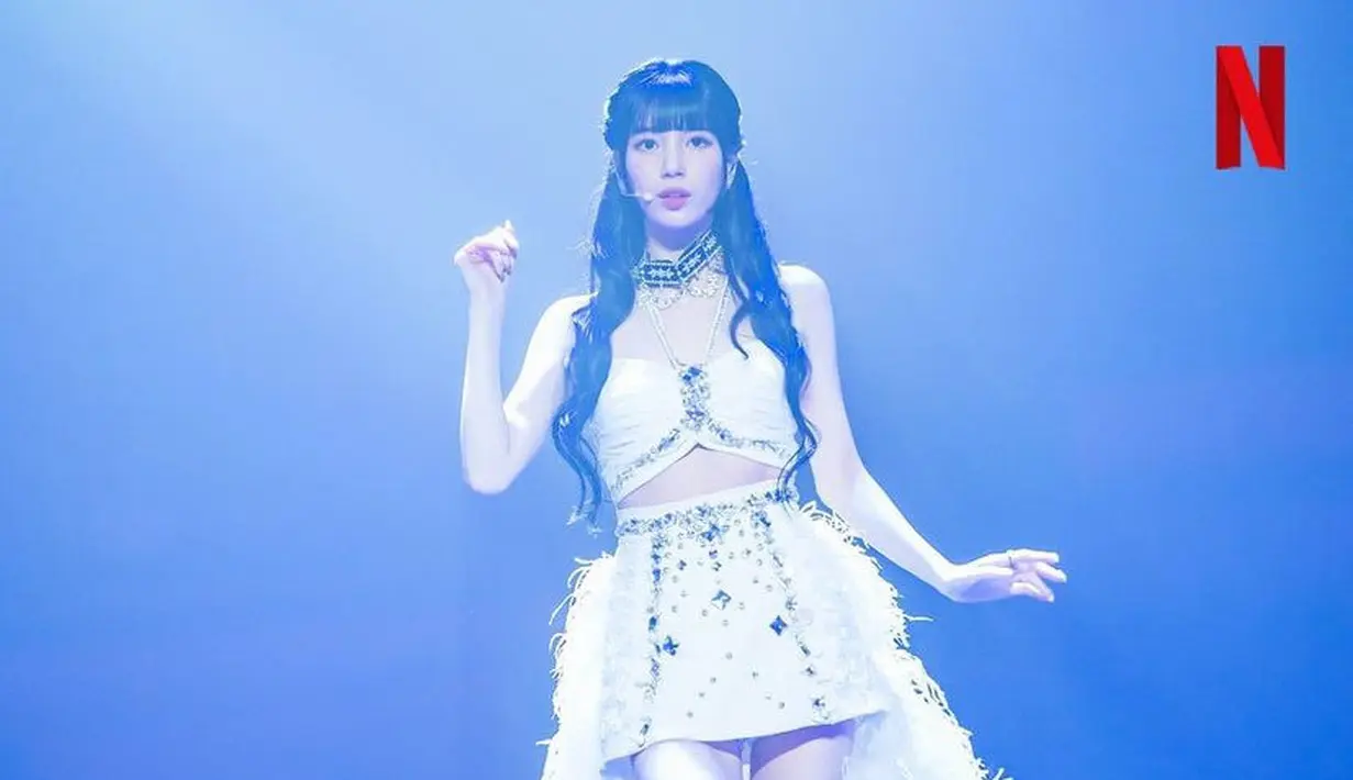 Two pieces putih tersebut terdiri dari atasan halter neck dengan aksen manik-manik, serta mini skirt manik-manik ditambah bulu-bulu di bagian belakang. [Netflix]