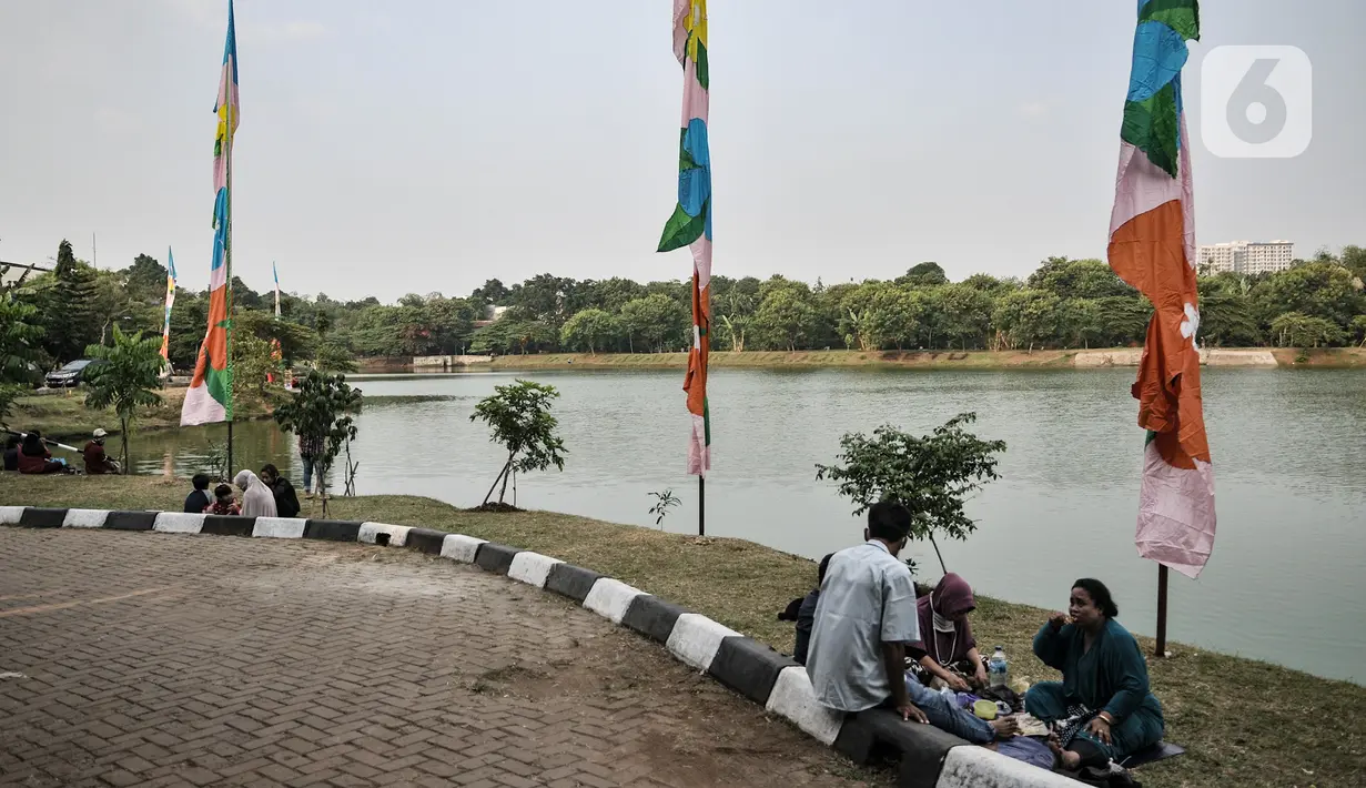 Warga saat bersantai di pinggir Waduk Setu, Cipayung, Jakarta, Selasa (28/7/2020). Saat ini Waduk Setu tengah dibuat jalur olahraga dan juga akan dilengkapi sarana bermain anak serta pusat kuliner yang diharapkan meningkatkan potensi kawasan ekonomi pariwisata. (merdeka.com/Iqbal S. Nugroho)