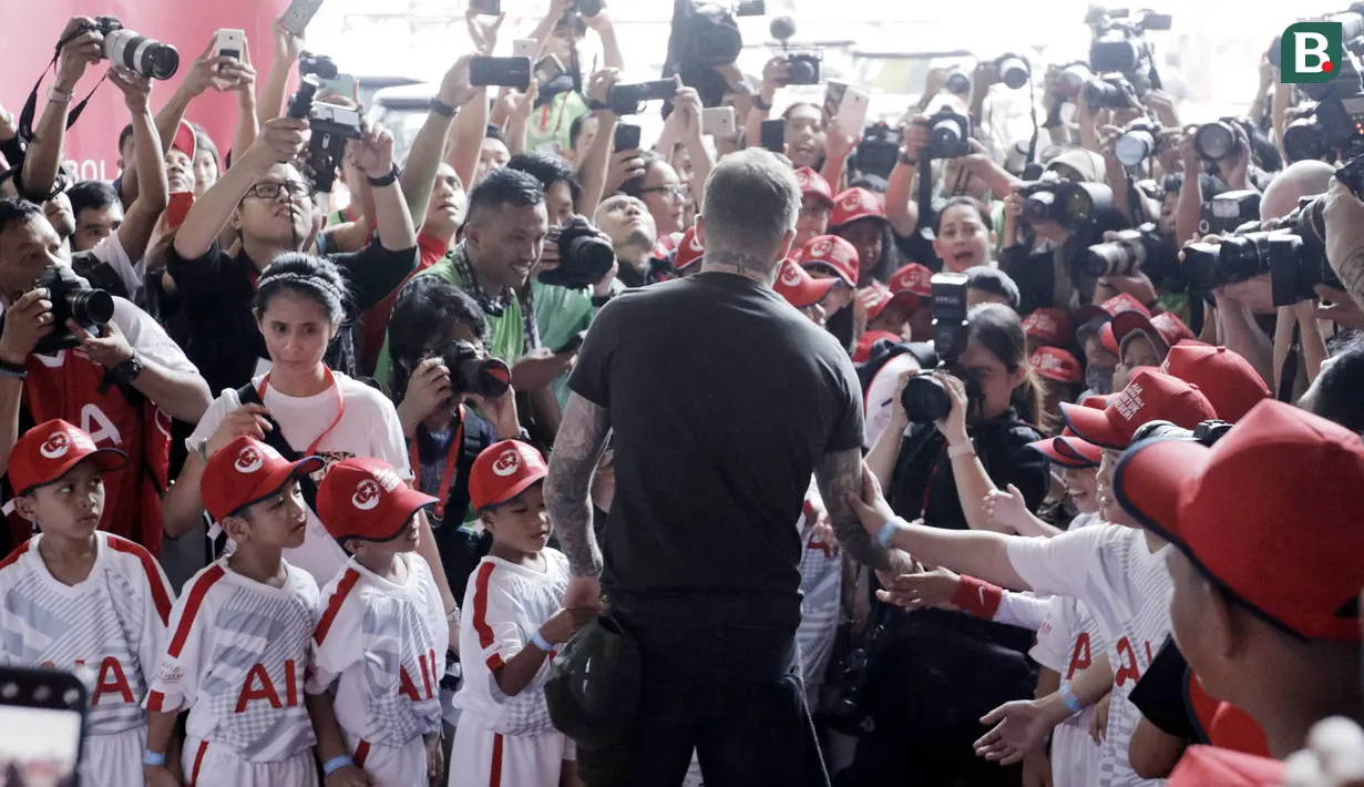 Legenda sepak bola Inggris, David Beckham, menyapa fans cilik di Stadion Soemantri Brodjonegoro, Jakarta, Minggu (25/3/2018). AIA membagikan 10.000 bola kepada akademi sepak bola di Indonesia. (Bola.com/M Iqbal Ichsan)