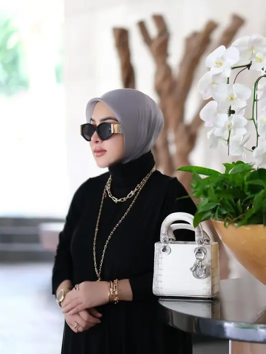 Dalam unggahan di akun Instagram, penampilan Syahrini memakai outfit serba hitam yang dipadukan hijab abu-abu ini curi perhatian. Terlebih, dirinya juga terlihat memakai kalung dari Tiffany & Co dengan harga ditaksir capai Rp 1,2 miliar. (Liputan6.com/IG/@PrincesSyahrini)
