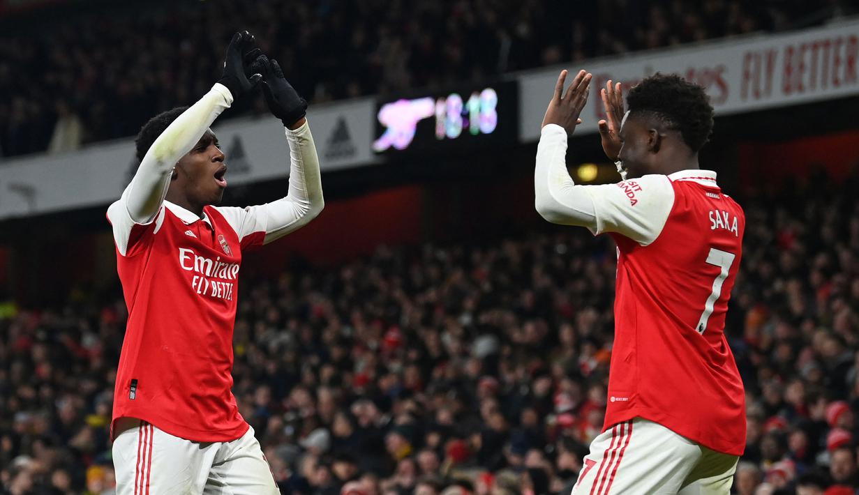 Pemain Arsenal, Eddie Nketiah melakukan selebrasi bersama rekannya, Bukayo Saka setelah mencetak gol ketiga timnya ke gawang Manchester United pada laga lanjutan Liga Inggris 2022/2023 yang berlangsung di Emirates Satdium, London, Minggu (23/01/2023). Arsenal berhasil menang dengan skor 3-2 atas Manchester United. (AFP/Glyn Kirk)