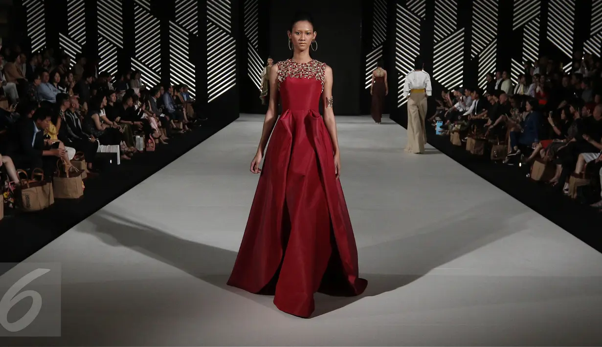 Model mengenakan busana rancangan Andreas Odang pada malam pembukaan Senayan City Fashion Nation ke-11, Kamis (6/4). Bertajuk La Memoire, Odang juga tidak segan bermain dengan koleksi kain khas Indonesia yaitu tenun. (Liputan6.com/Herman Zakharia)