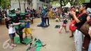 Beberapa anak berfoto dengan manusia patung di kawasan Monumen Nasional, Jakarta, Minggu (25/12). Libur perayaan Natal 2016 dimanfaatkan sejumlah warga untuk berwisata di kawasan Monumen Nasional. (Liputan6.com/Helmi Fithriansyah)