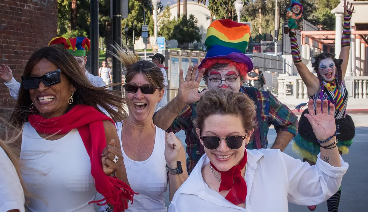 Pejalan kaki berlarian dikejar oleh peserta berdandan seperti badut selama acara parodi tahunan "Running of the Clowns"d i Pasadena, California pada 20 Oktober 2019. Lari dikejar kawanan badut ini merupakan parodi yang mengolok-olok lomba dikejar banteng di Spanyol. (Mark RALSTON / AFP)