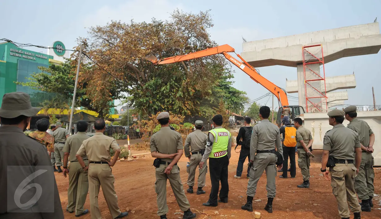Sejumlah petugas melihat alat berat yang membongkar bangunan di kawasan Pangkalan Jati, Bekasi, Kamis (8/10). Pembongkaran dilakukan untuk mempersiapkan lahan pembangunan Jalan Tol Bekasi Cawang Kampung Melayu (Becakayu). (Liputan6.com/Gempur M Surya)