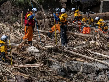 Petugas penyelamat mencari orang-orang yang hilang dalam puing-puing yang hanyut akibat banjir di sungai Tsukada setelah hujan lebat di kota Wajima, prefektur Ishikawa pada Senin 23 September 2024. (Yuichi YAMAZAKI/AFP)