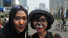 Para peserta tampak melukiskan wajahnya saat mengikuti aksi Karnaval untuk Bumi, Jakarta, (12/10/14). (Liputan6.com/Miftahul Hayat)