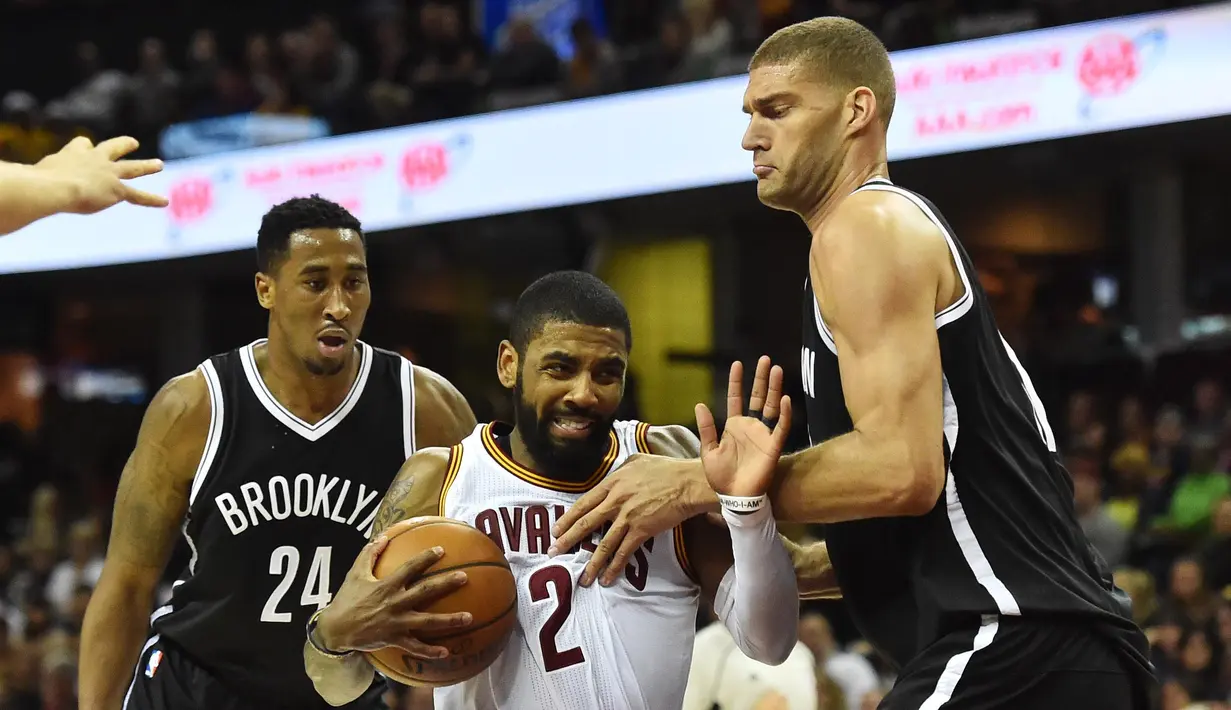 Ekspresi pemain Cleveland Cavaliers, Kyrie Irving (2) saat berusaha melewati hadangan pemain  Brooklyn Nets, Brook Lopez (11) pada lanjutan NBA di Quicken Loans Arena, (23/12/2016). (Reuters/Ken Blaze-USA TODAY Sports)