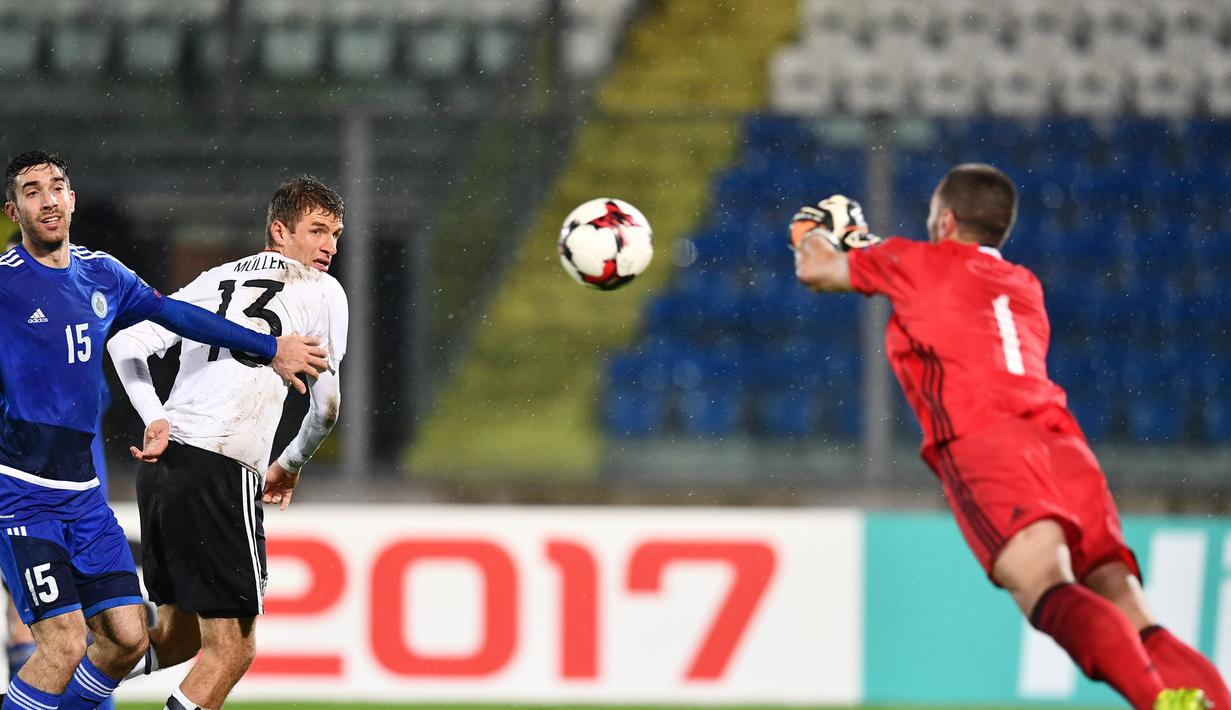  Pemain Jerman, Thomas Mueller (2kiri) menyundul bola ke arah gawang San Marino pada laga grup C kualifikasi Piala Dunia 2018 di San Marino stadium, Serravalle, (11/11/2016). (AFP/Vincenzo Pinto)