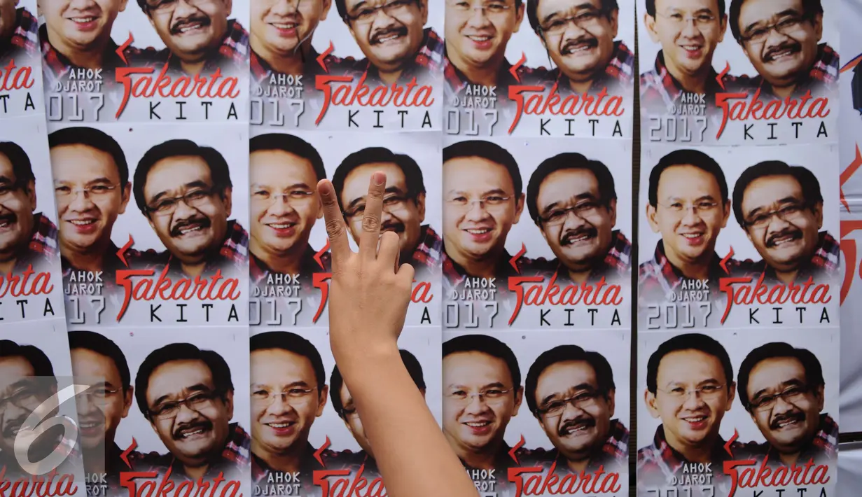 Salam dua jari didepan poster Calon Gubernur dan Wakil Gubernur DKI Jakarta Nomor Urut Dua, Ahok-Djarot saat kegiatan pengobatan gratis di Pengadegan Barat, Pancoran, Jakarta, Kamis (26/1). (Liputan6.com/Gempur M. Surya)