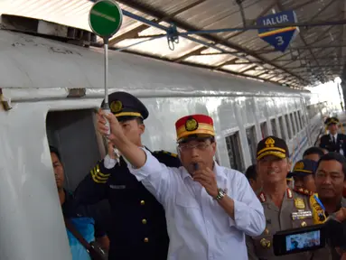 Menteri Perhubungan (Menhub) Budi Karya Sumadi meniup peluit keberangkatan KA Tawang Jaya di Stasiun Semarang Poncol, Jawa Tengah, Kamis (29/6). Menhub melakukan pengecekan kesiapan arus balik Lebaran 2017 di stasiun tersebut (Liputan6.com/Gholib)
