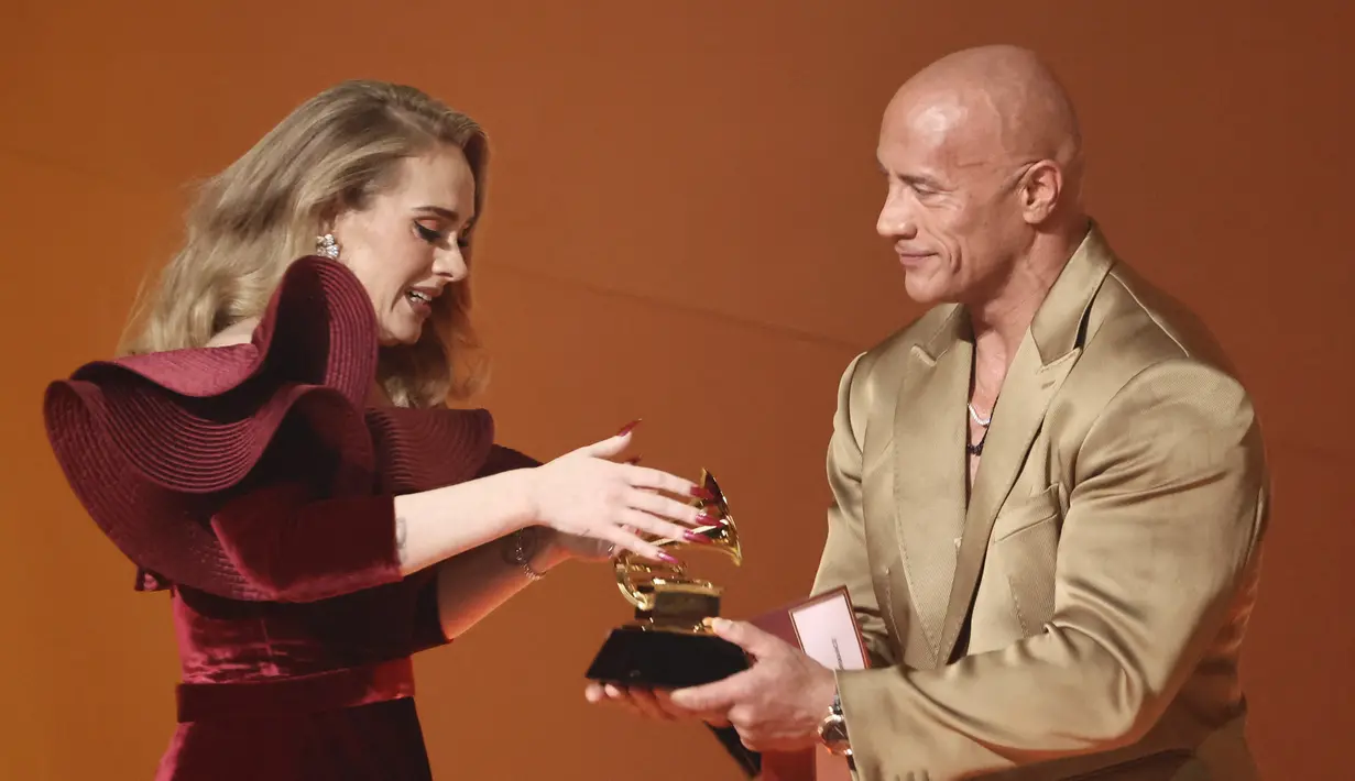 <p>Adele bergembira saat bertemu dengan Dwayne Johnson selama acara GRAMMY Awards ke-65 di Crypto.com Arena di Los Angeles, California pada 5 Februari 2023. Penyanyi 34 tahun ini kembali masuk nominasi Grammy sejak 2017. Kala itu, Adele memborong Album of The Year, Record of The Year, dan Song of The Year. (Frazer Harrison/Getty Images/AFP)</p>