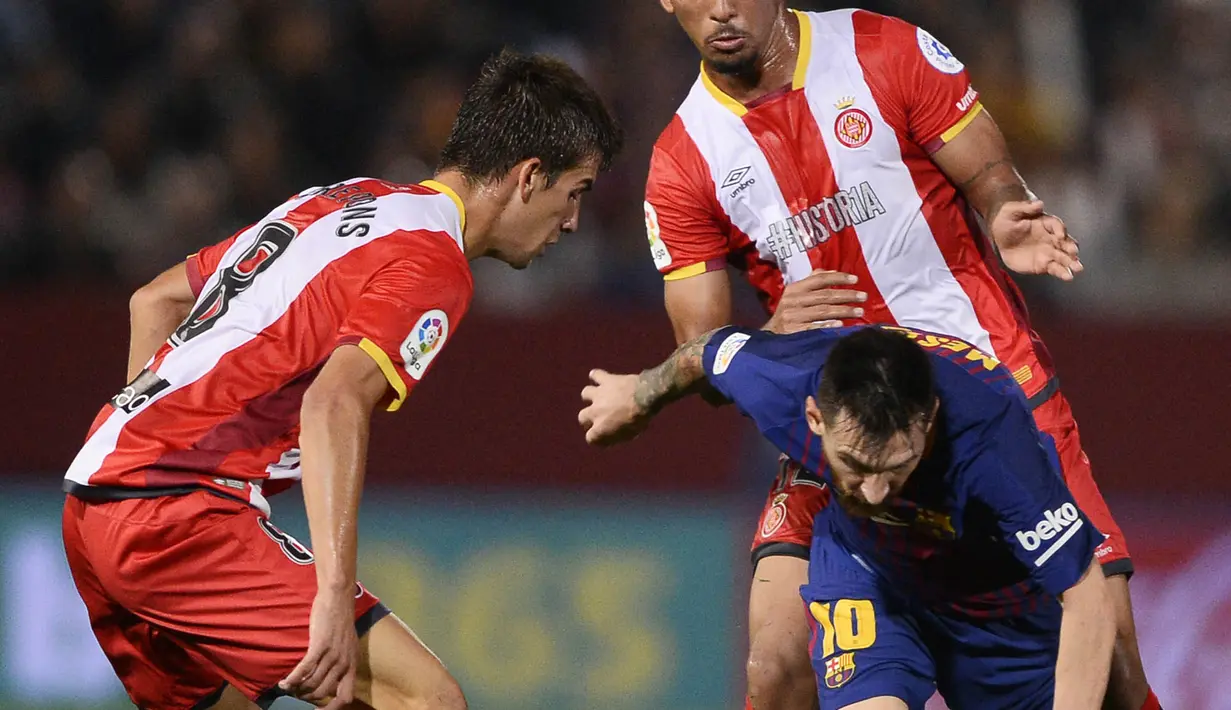 Bintang Barcelona, Lionel Messi, berusaha melewati hadangan pemain Girona pada laga La Liga Spanyol di Stadion Montilivi, Girona, Sabtu (23/9/2017). Girona kalah 0-3 dari Barcelona. (AFP/Josep Lago)