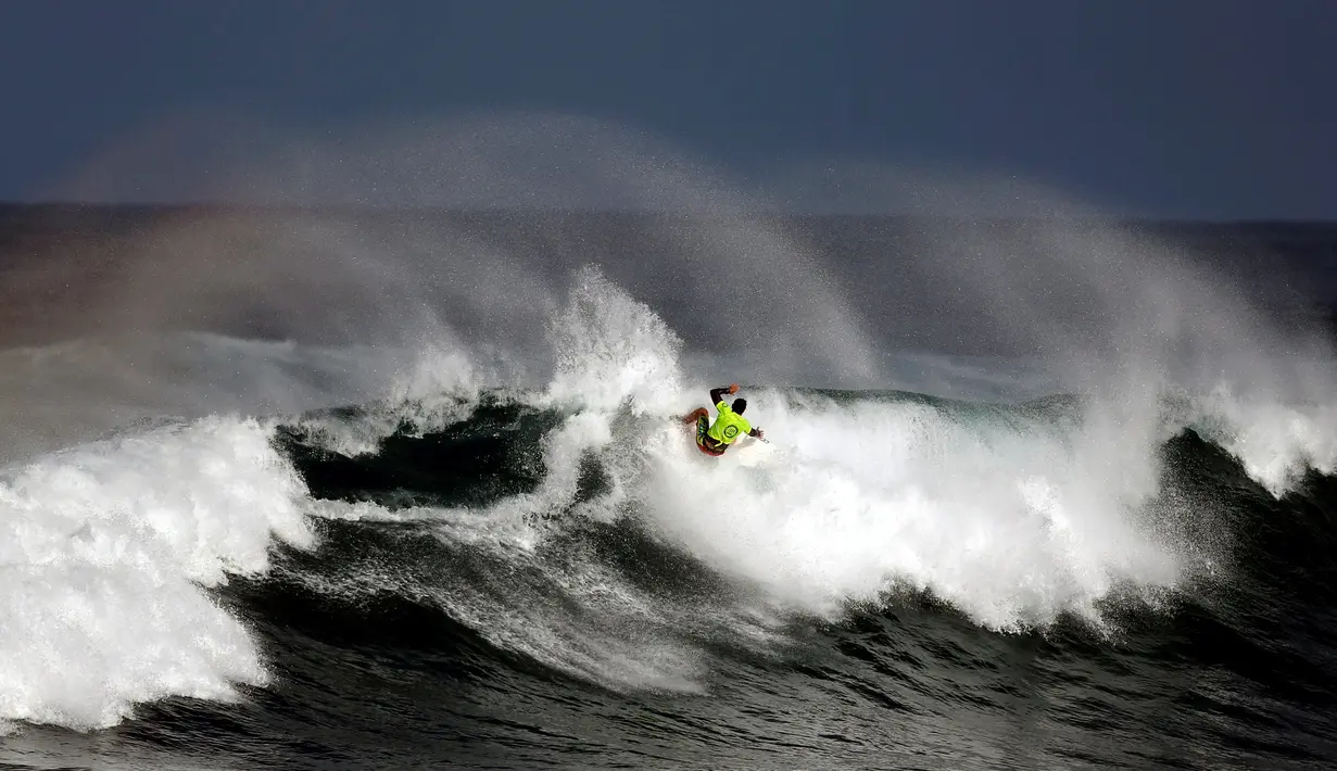 Seorang peserta beraksi menaklukan ombak selama mengikuti dalam kompetisi surfing di laut Mediterania di Ashdod, Israel, (17/11). (REUTERS/Amir Cohen)