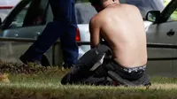 Seorang pria menggunakan telepon genggamnya dekat polisi bersenjata setelah insiden penembakan di Masjid Al Noor, Christchurch, Selandia Baru, Jumat (15/3). (AP Photo/Mark Baker)