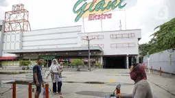 Pengunjung melintas di depan Supermarket Giant Ekstra di Kreo, Tangerang, Senin (2/8/2021). PT Hero Supermarket Tbk resmi menutup seluruh gerai Giant di Indonesia pada Minggu (1/8/2021), dan akan lebih fokus pada pengembangan gerai merek lainnya. (Liputam6.com/Faizal Fanani)