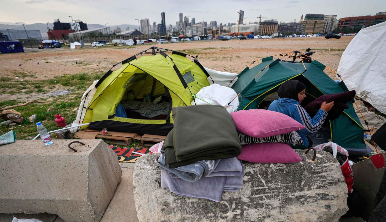 Sebelumnya, diperkirakan, ada lebih dari 1,1 juta orang termasuk anak-anak dan perempuan di Lebanon mengungsi akibat konflik antara Hizbullah Lebanon dengan Israel yang memanas sejak Maret 2026. Tampak dalam foto, seorang wanita pengungsi mengemasi barang-barang keluarganya, bersiap untuk kembali ke rumah setelah gencatan senjata antara Hizbullah dan Israel di Beirut, Lebanon, Jumat 17 April 2026. (AP Photo/Hussein Malla)