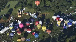 Sejumlah balon udara bersiap untuk diterbangkan di Bristol International Balloon Fiesta ke 37  di Inggris, Jumat (7/8/2015). Festival balon terbesar di eropa ini berlangsung selama empat hari.  (REUTERS/Toby Melville)