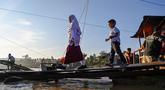 Sejumlah siswa menaiki perahu darurat untuk menyeberangi Sungai Peusangan pasca banjir bandang yang menghancurkan desa-desa di sekitarnya di kabupaten Bireuen, provinsi Aceh, Indonesia pada Senin 5 Januari 2026. Secara resmi, Dinas Pendidikan dan Kebudayaan (Disdikbud) Bireuen telah menetapkan jadwal masuk sekolah usai libur semester pada Senin (5/1/2025). (CHAIDEER MAHYUDDIN/AFP)