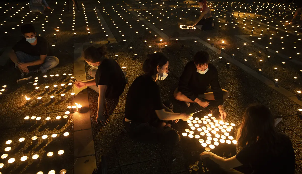 Warga menyalakan lilin pada peringatan 25 tahun pembunuhan Perdana Menteri Israel Yitzhak Rabin, di Rabin Square, Tel Aviv, Kamis (29/10/2020). Yitzhak Rabin ditembak ekstremis Yahudi, Yigal Amir usai melakukan pidato perdamaian Kings of Israel Square pada 4 November 1995. (AP Photo/Oded Balilty)