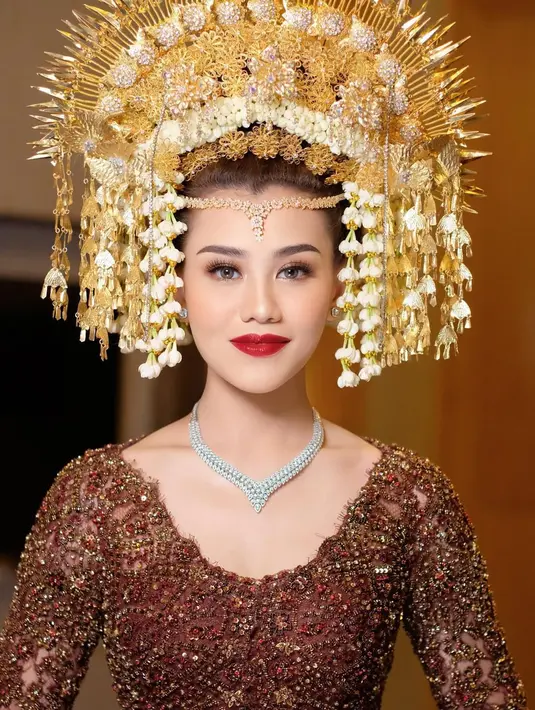 Di momen ini, penampilan Aaliyah Massaid semakin menonjol dengan riasan wajah yang bold, pulasan lipstik merah, dan suntiang emas khas Minang. [Foto: Instagram/marlenehariman]