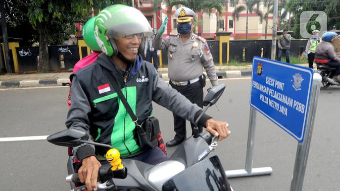 Petugas Lantas Polda Metro Jaya menyuruh pengemudi ojek online yang tidak memakai masker untuk kembali balik ke arah Ciputat saat kegiatan Check Point Pengawasan Pelaksaanaan PSPBB di kawasan Pasar Jumat, Jakarta selatan, Jumat (10/4/2020). (merdeka.com/Arie Basuki)