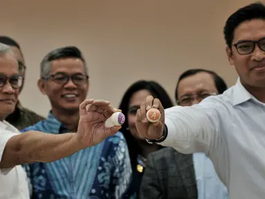 Direktur Program TKN Jokowi-Ma'ruf Amin, Aria Bima dan Direktur Eksekutif BPN Prabowo-Sandi, Sudaryono menunjukkan bola saat pengundian zona kampanye rapat umum untuk peserta Pemilu 2019 di Kantor KPU RI, Jakarta, Rabu (6/3). (merdeka.com/Iqbal S Nugroho)