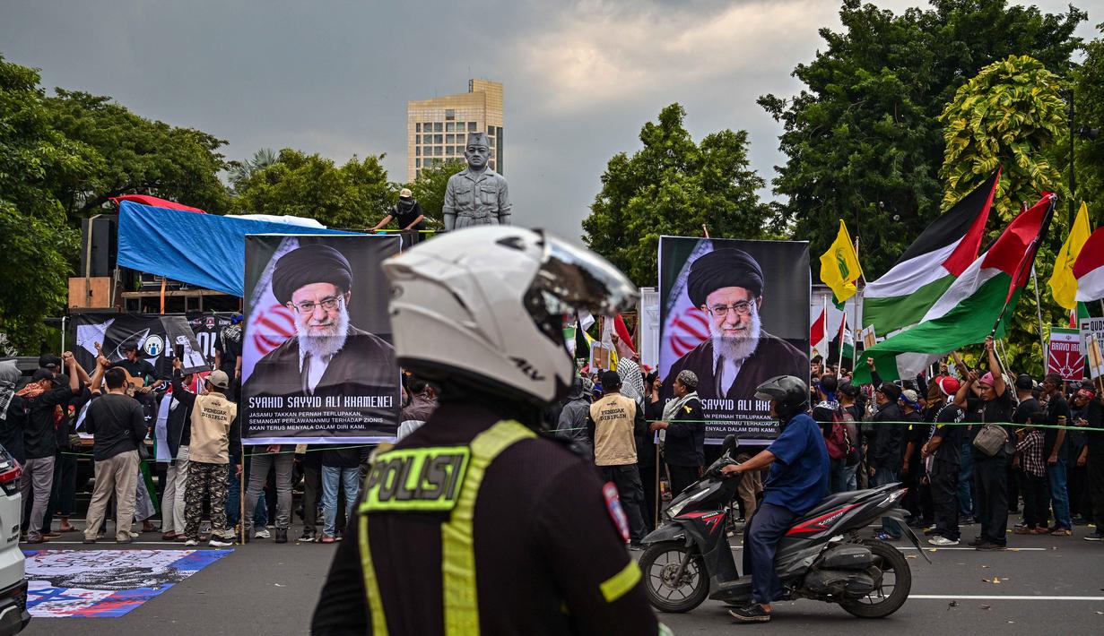 Al-Quds atau Quds sendiri adalah nama Arab untuk Yerusalem. Tampak dalam foto, spanduk bergambar pemimpin tertinggi Iran, Ayatollah Ali Khamenei yang gugur dalam serangan Amerika Serikat dan Israel pada akhir Februari lalu, ditunjukkan dalam aksi unjuk rasa memperingati Hari Al-Quds, di Surabaya, Jawa Timur, Jumat (13/3/2026). (Juni KRISWANTO/AFP)