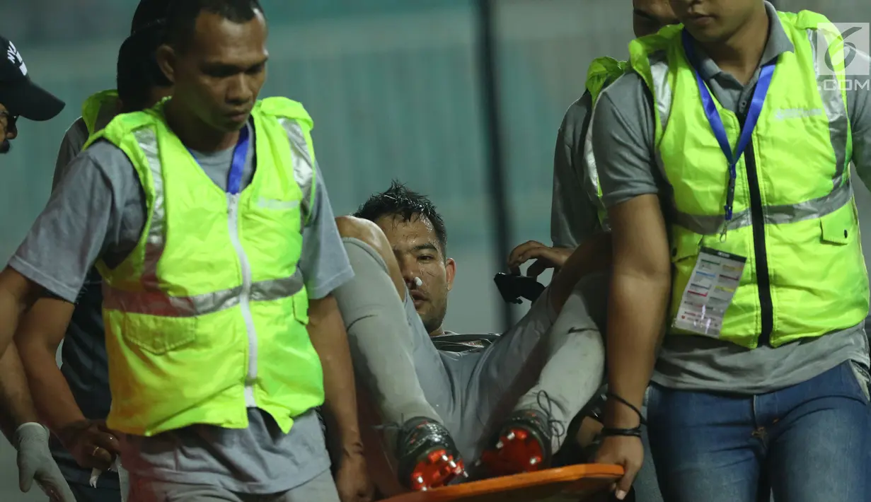 Penjaga gawang Indonesia U-23, Andritany ditandu keluar lapangan saat laga melawan Uzbekistan pada PSSI Anniversary 2018 di Stadion Pakansari, Kab Bogor, Kamis (3/5). Babak pertama imbang 0-0. (Liputan6.com/Helmi Fithriansyah)