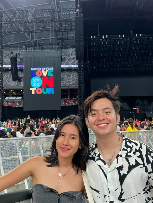 Momen Angga dan Shenina nonton konser Harry Styles di Singapura. Pamer senyum bahagia karena nonton konser Harry Styles bareng, tak sedikit netizen yang juga turut bahagia melihat kebersamaan Angga dan Shenina. Pasangan ini selaras dengan busana warna monokrom, Angga dan Shenina jadi makin serasi karena kalung yang dikenakannya juga kembar. (Liputan6.com/IG/@angga)