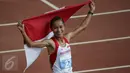 Atlet Indonesia, Rini Budiarti membentangkan bendera Merah Putih usai finish pertama lari halang rintang 3.000 meter SEA Games ke-28 di National Stadium, Singapura, (12/6/2015). Rini mencatat waktu 10 menit 20,40 detik. (Liputan6.com/Helmi Fithriansyah)