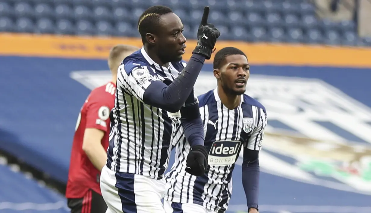Pemain West Bromwich Albion, Mbaye Diagne, melakukan selebrasi usai mencetak gol ke gawang Manchester United pada laga Liga Inggris di Stadion Hawthorns, Minggu (14/2/2021). Kedua tim bermain imbang 1-1. (Naomi Baker/Pool Photo via AP)