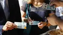 Uang kertas pecahan 5 pound tersebut juga dilengkapi fitur keamanan, termasuk penggunaan kertas lapisan emas pada gambar Big Ben di bagian depan dan perak di belakang uang kertas tersebut, London, Selasa (13/9). (REUTERS / Stefan Wermuth)