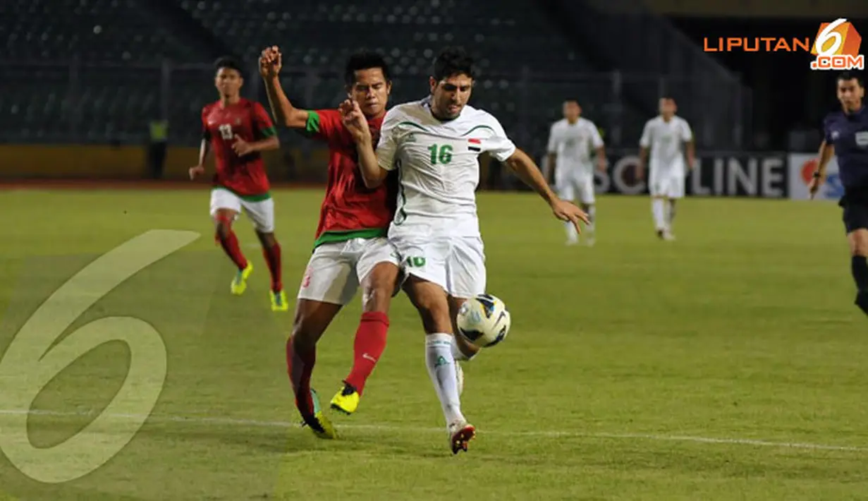 Pemain belakang Indonesia M Roby (16) berusaha menahan laju serangan pemain Irak M Karrar saat laga kualifikasi Piala Asia 2015 (Liputan6.com/Helmi Fithriansyah)